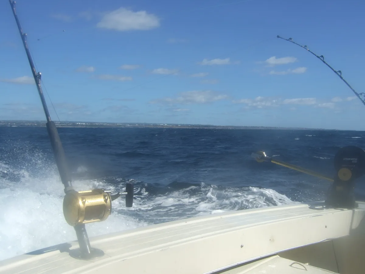 Canas de corrico na popa de um barco, com carretos de pesca grossa